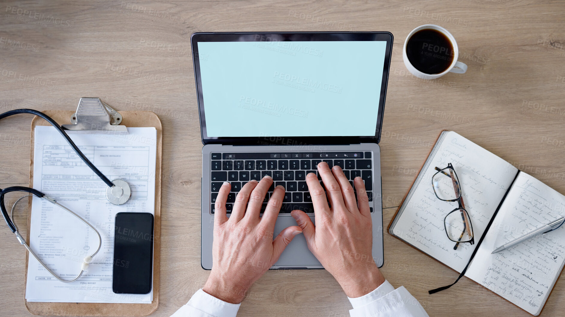 Buy stock photo Healthcare, hands and laptop with a man doctor working at a desk in his office on a report from above. Medical, notebook and documents with a male medicine professional typing feedback on a computer