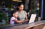 Black family, internet cafe or laptop with a mother and daughter together in the window of a restaurant. Kids, computer or education with a woman and female child sitting or bonding in a cafe
