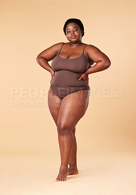 Buy stock photo Portrait, wellness and plus size with a model black woman posing hands on hips in studio on a beige background. Beauty, underwear and natural with a female sitting on a stool for body positivity