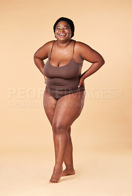 Buy stock photo Portrait, happy or plus size with a model black woman posing hands on hips in studio on a beige background. Wellness, underwear and smile with a female standing proud or confident for body positivity