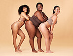 Diversity women, body size and portrait of group together for inclusion, beauty and power. Underwear model friends happy on beige background with cellulite legs, skin pride and self love motivation