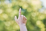 Hand, index finger and pointing in nature, outdoors or at park at something. Direction, bokeh and hands point up for gesture, signal or sign language, counting fingers or emoji, mathematics or timer.