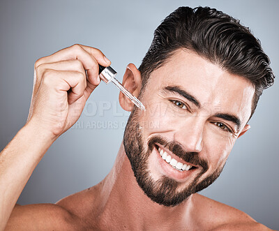 Buy stock photo Man, face and cosmetic serum for skincare, beauty and facial care, oil product in hand isolated on studio background. Portrait, smile and moisturizer, wellness and dermatology for healthy skin glow