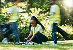 Black woman volunteer, cleaning park and community service for recycling and pollution. Black woman happy to help ngo group with plastic bottle, dirt and trash bag outdoor in green environment