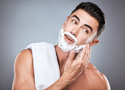 Buy stock photo Face, shave foam and grooming with a man model in studio on a gray background for hair removal. Beard, hand and skincare with a handsome young male in the bathroom for shaving in the morning