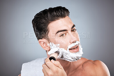 Buy stock photo Shaving cream, face and man with brush in studio isolated on a gray background for hair removal. Beard care portrait, grooming and male model with facial product, foam or gel to shave for wellness.