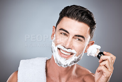 Buy stock photo Brush, shaving cream and face of man in studio isolated on a gray background for hair removal. Beard care portrait, skincare and male model with facial product, foam or gel to shave for wellness.