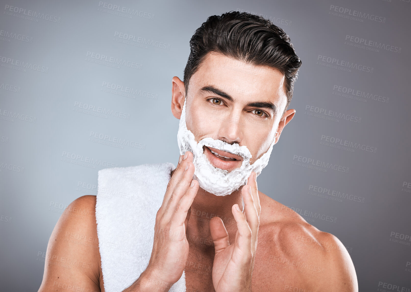 Buy stock photo Face, shaving cream and grooming with a man model in studio on a gray background for hair removal. Shave, hands and skincare with a handsome young male in the bathroom for a shave in the morning