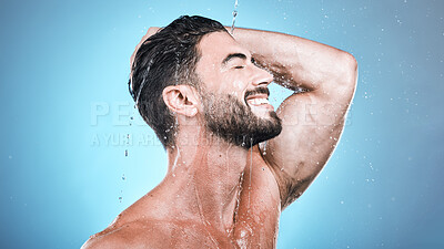 Buy stock photo Face skincare, water splash and man in shower in studio isolated on a blue background. Wellness, dermatology and happy male model cleaning, washing and bathing for healthy skin, self care and hygiene