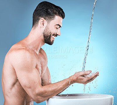 Buy stock photo Water splash, skincare and man cleaning hands in studio isolated on blue background for wellness, healthy skin or hydration. Hygiene, dermatology or smile of happy male model bathing or washing hand.