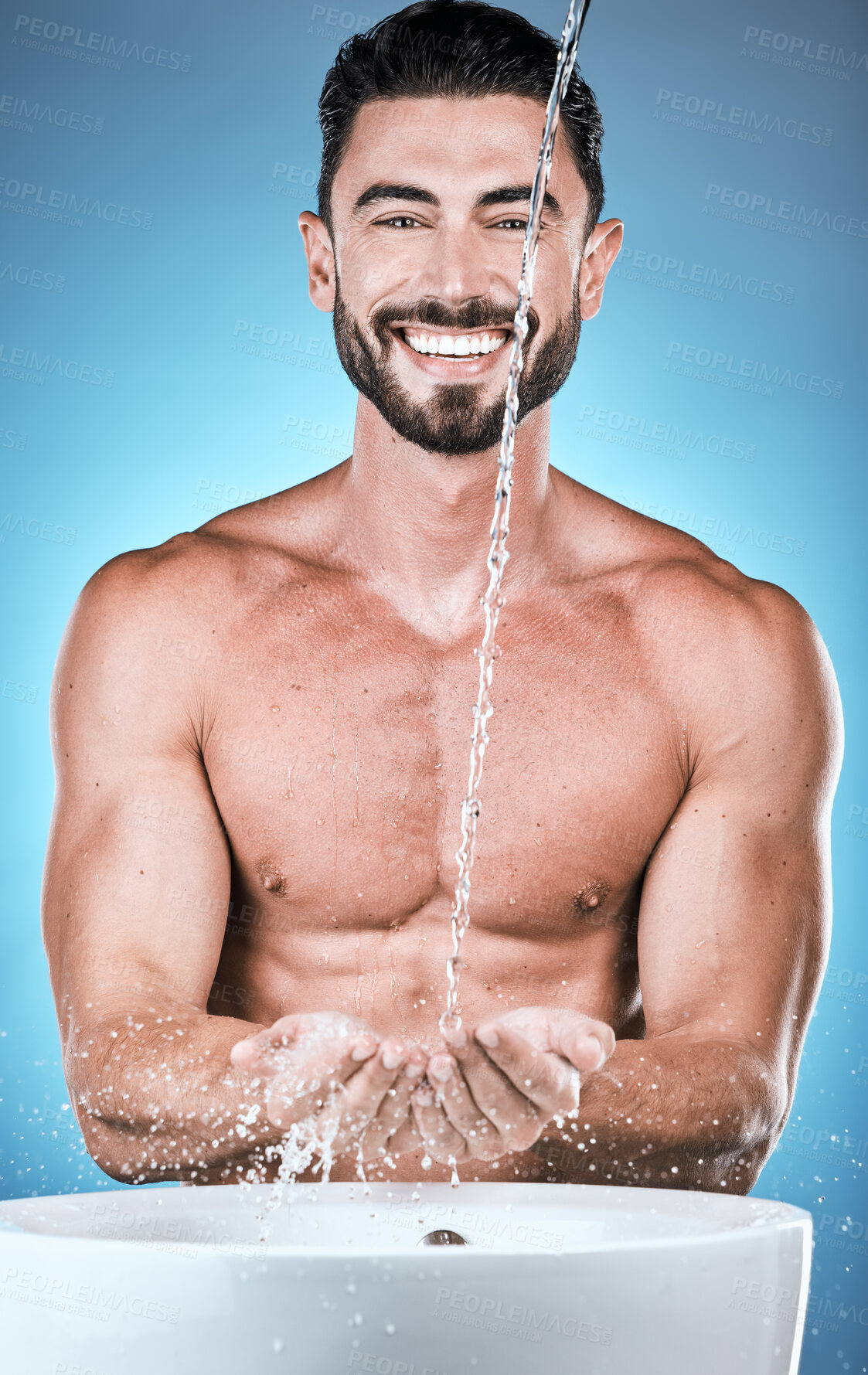 Buy stock photo Portrait, water splash and man cleaning hands in studio isolated on a blue background for wellness, healthy skin or grooming. Hygiene dermatology, skincare and male model bathing or washing hand.