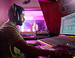 Black man, studio recording and music job in night with headphones, computer or focus by mixing console. Sound engineer, producer or audio technology for professional production of hit song for radio