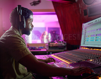 Buy stock photo Black man, studio recording and music job in night with headphones, computer or focus by mixing console. Sound engineer, producer or audio technology for professional production of hit song for radio