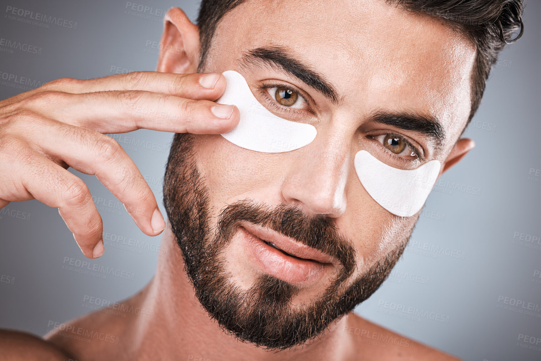 Buy stock photo Face, skincare and man with eye patches in studio isolated on a gray background for wellness. Portrait, dermatology and male model with cosmetics, facial treatment or mask product for healthy skin.