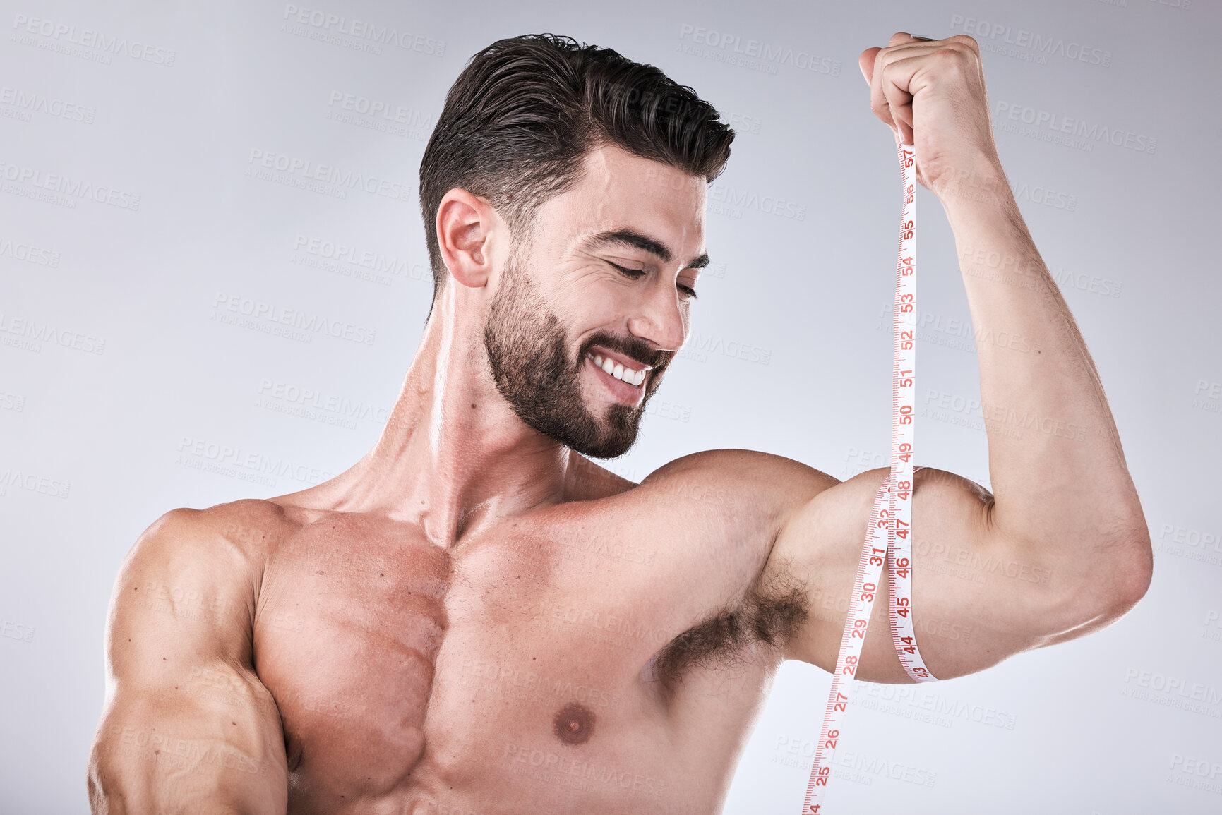 Buy stock photo Fitness, body and strong man with tape measure for biceps for exercise goals on studio background. Happy bodybuilder measuring arm for training, workout or muscle growth progress, results or target