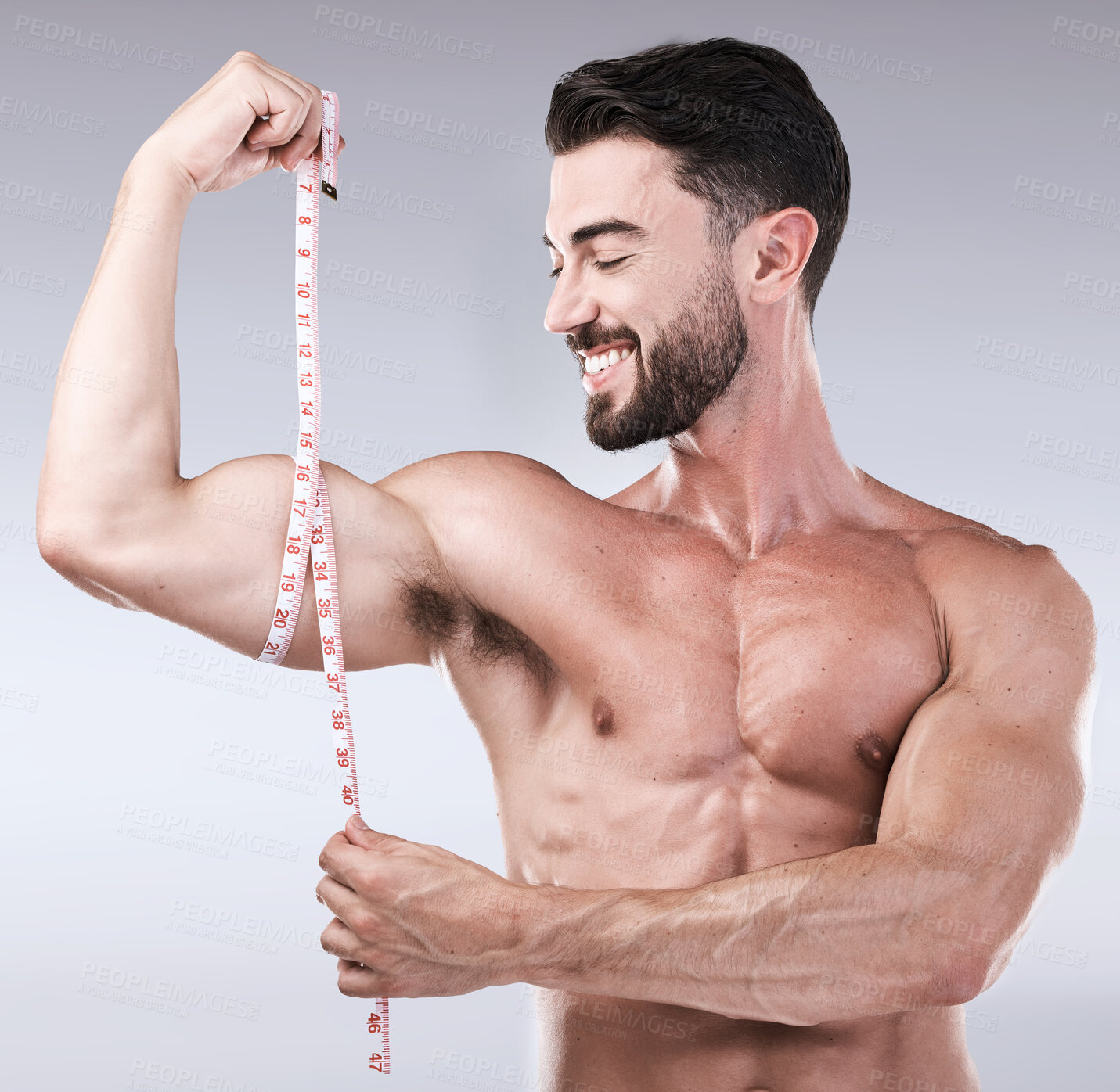 Buy stock photo Fitness, goals or strong man with tape measure for biceps after body exercise on studio background. Happy bodybuilder measuring arm for training, workout or muscle growth progress, results or target