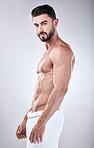 Muscular man, standing and smile with towel for clean hygiene, wash or skincare isolated on gray studio background. Portrait of attractive male model smiling for fit body, cosmetics or fresh grooming