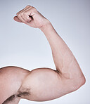 Arm muscle, man and fist with body, health and fitness with strong person isolated on studio background. Skin, bodybuilder and flex biceps, wellness and weightlifting, exercise growth and muscular