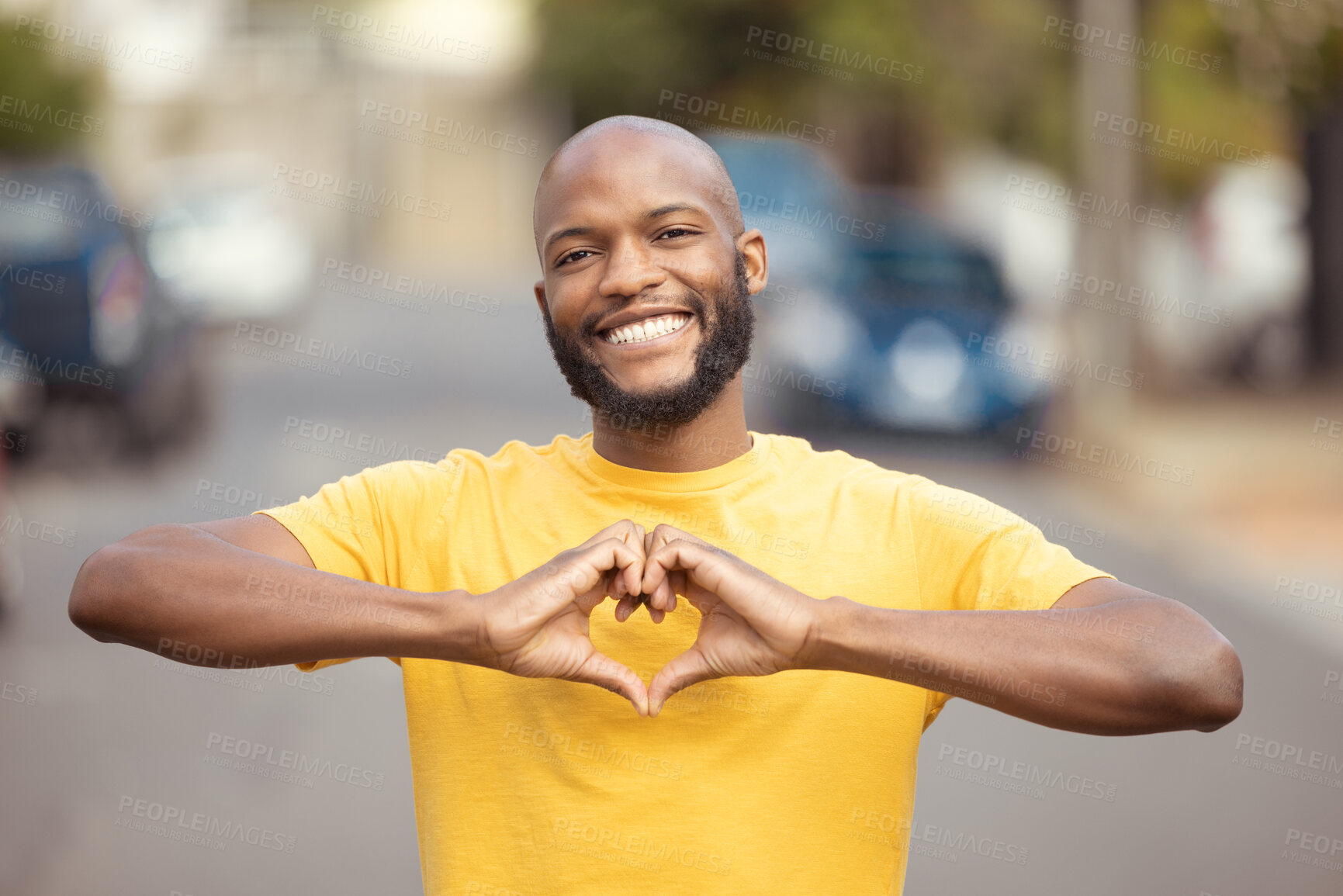 Buy stock photo Portrait, man and hand, heart and love in a city, happy and smile against blurred background space. Emoji, hands and face of male relax with finger, frame and loving message, gesture and travel sign