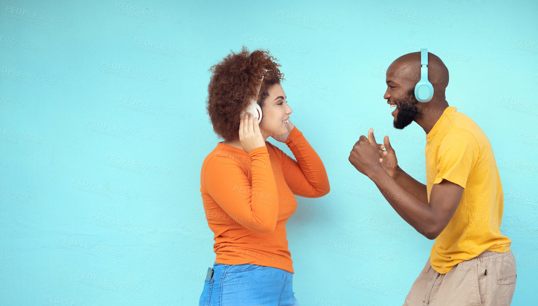 Buy stock photo Couple of friends in headphones isolated on a blue background for dancing, celebration and listening to music. Black woman with dance partner or people with audio, podcast and gen z technology mockup