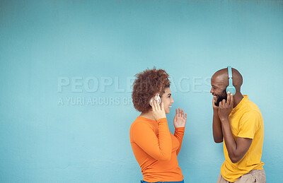Buy stock photo Couple of friends listening to music isolated on a blue background with headphones for gen z mockup space. Black woman with happy partner or people with audio, podcast and youth technology mock up