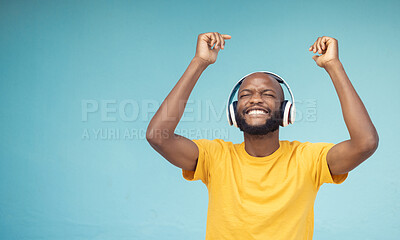 Buy stock photo Music, dance and mockup with a black man in studio on a blue background wearing headphones. Radio, freedom and fun with a male dancing indoor alone while streaming an online audio playslist