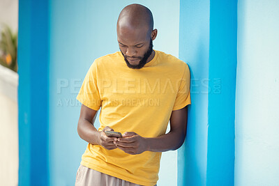 Buy stock photo Thinking black man, phone or typing on blue background on social media, internet app or reading news blog. Fashion clothes, person or student on mobile technology with fashion clothes ideas or vision