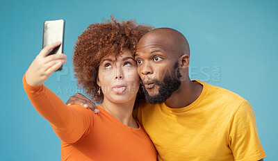 Buy stock photo Couple, hug and funny faces selfie on blue background, isolated mockup or wall mock up for social media. Comic, goofy and silly black man and woman on photography tech for interracial profile picture