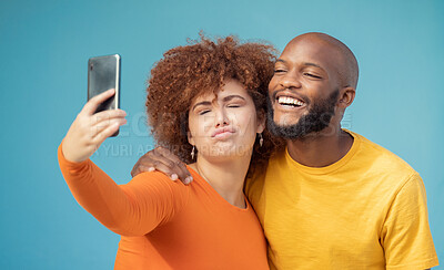 Buy stock photo Couple, bonding or funny faces selfie on blue background, isolated mockup or wall mock up on social media. Comic, goofy or silly man and woman on photography technology in interracial profile picture