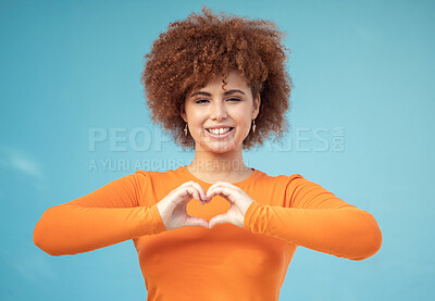 Buy stock photo Heart, hand and portrait of woman in studio for love, happy and smile against blue background space. Emoji, hands and face of girl model relax with finger, frame and loving message, gesture and sign 