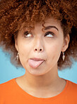 Comic, tongue and face with a black woman in studio on a blue background feeling funny or silly. Comedy, joke and humor with an attractive young female looking goofy while posing alone indoor