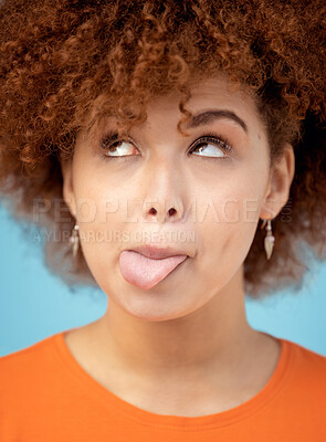 Buy stock photo Comic, tongue and face with a black woman in studio on a blue background feeling funny or silly. Comedy, joke and humor with an attractive young female looking goofy while posing alone indoor