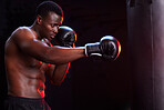 Boxer, fitness and black man isolated on a dark background or gym training focus, challenge and bodybuilder fist impact. Strong, power and boxing athlete or sports person with exercise in mma gear