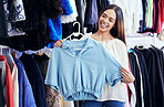Fashion, shopping or clothes with a black woman customer in a store for retail to buy a contemporary shirt. Sale, style and smile with a female consumer or shopper buying clothing in a boutique 