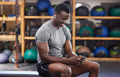 Buy stock photo Phone, fitness and black man in gym training, workout or exercise social media or internet search for health tips. Bodybuilder, sports person listening to music or typing on smartphone chat or mobile
