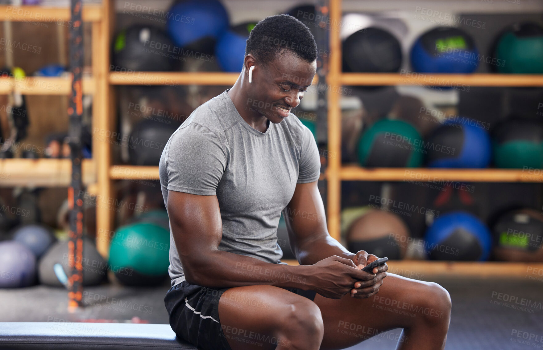 Buy stock photo Phone, fitness and black man in gym training, workout or exercise social media or internet search for health tips. Bodybuilder, sports person listening to music or typing on smartphone chat or mobile