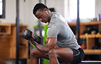 Fitness, dumbbell and black man doing a workout in the gym for intense arm strength training. Sports, motivation and strong African male bodybuilder doing a exercise with weights in a sport center.