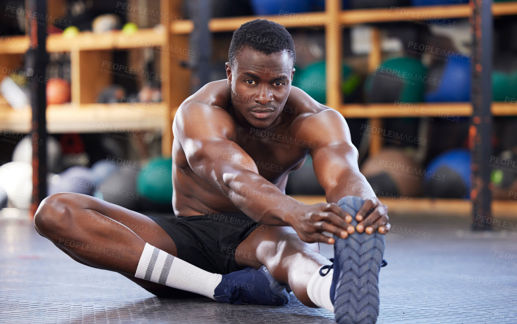 Buy stock photo Stretching, training and portrait of black man in gym for sports, workout and performance. Wellness, exercise and fitness with athlete and warm up legs on floor for cardio, endurance and energy