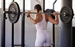 Barbell exercise, woman and back view for fitness, health and sports challenge in gym. Female athlete, bodybuilder and weightlifting for wellness, power and energy in workout, performance or training