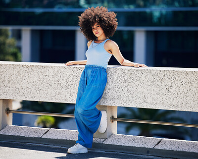 Buy stock photo Portrait, fashion and serious with a black woman in the city on a bridge, looking relaxed during summer. Street, style or urban and an attractive young female posing outside with an afro hairstyle