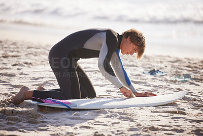 Fitness, beach and man waxing his surfboard before a sport competition, practice or training. Sports, surfing and male surfer preparing for a water workout or exercise in the ocean in Australia.