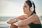 Headphones, fitness and relax woman on beach for wellness, mental health and health in morning sky mockup. Thinking, ideas and calm sports person listening to music or peace podcast  by ocean or sea