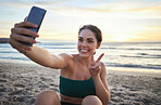 Selfie, fitness and woman on beach peace sign, live streaming her workout, training or exercise results. Video call of sports, cardio person or gen z influencer relax on sand for runner break by sea