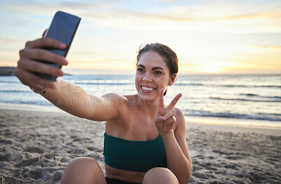 Buy stock photo Selfie, fitness and woman on beach peace sign, live streaming her workout, training or exercise results. Video call of sports, cardio person or gen z influencer relax on sand for runner break by sea