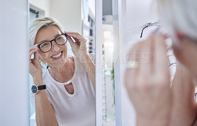 Buy stock photo Happy woman customer, glasses and mirror while shopping for lens or frame for eye care vision and wellness. Senior person with smile for making choice or decision for retail sale at optometry store