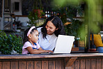 Learning, mother and girl with laptop at cafe for education and development online. Family, remote worker and happy woman teaching kid how to type on computer at restaurant, bonding and having fun.