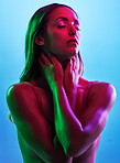 Glowing skincare, hands or touch in neon lighting on isolated blue background with neck, body or skin. Beauty, model or fashion woman in creative fantasy green, pink or lights aesthetic in cosmetics