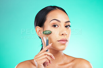 Buy stock photo Portrait, jade roller and woman with face massage in studio for wellness, grooming or skincare on isolated blue background. Beauty, facial and massaging tool by girl model relax, skin or product