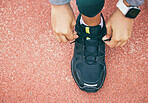 Hands, top view and woman tie shoes at running track, stadium or arena outdoors. Sports, training and black female athlete tying sneaker lace, getting ready and preparing for exercise, workout or run