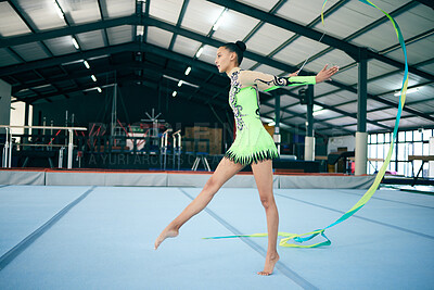 Buy stock photo Rhythmic gymnastics, fitness and woman in gym with ribbon, sport and graceful athlete on mat. Dance, girl gymnast and flexibility with pose and sports, mockup space with training or performance